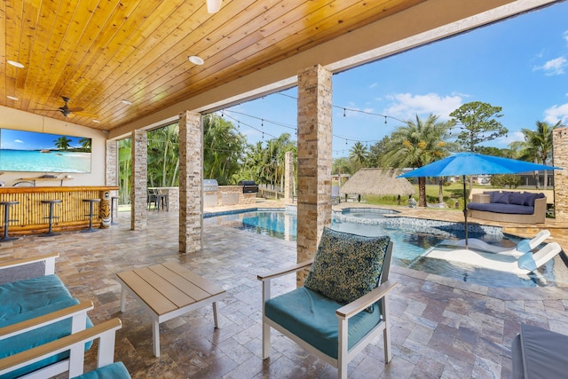 view of patio featuring an outdoor bar, exterior kitchen, a pool with connected hot tub, and an outdoor hangout area