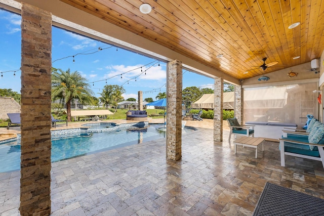 view of patio with ceiling fan and a pool with connected hot tub