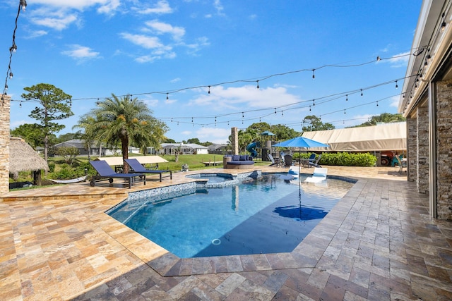 view of pool with a patio and a pool with connected hot tub