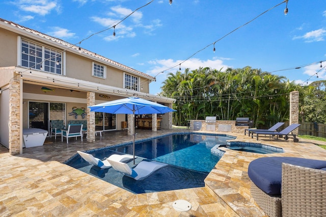 view of pool featuring exterior kitchen, a patio, and a pool with connected hot tub