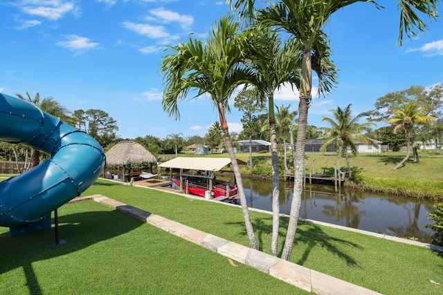 dock with a water view, a yard, and boat lift