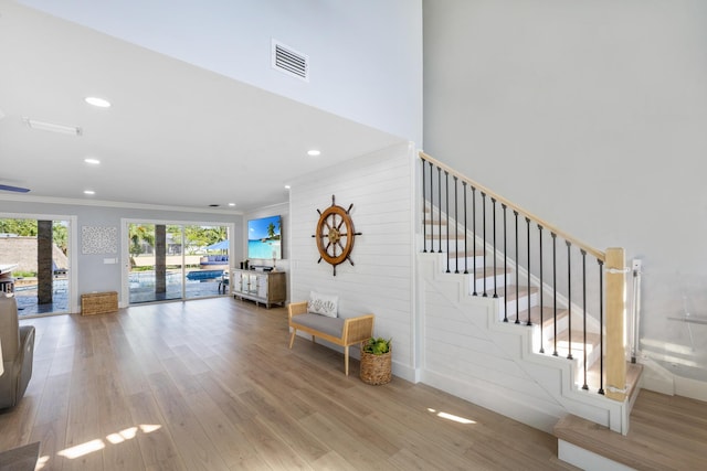 stairway featuring wood finished floors, recessed lighting, and crown molding