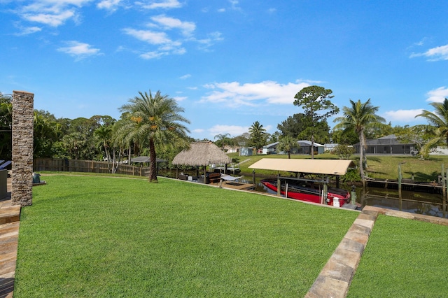 view of yard featuring a gazebo, boat lift, and a boat dock