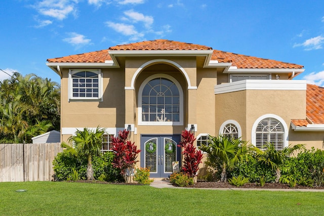 mediterranean / spanish home featuring french doors, stucco siding, and a tiled roof