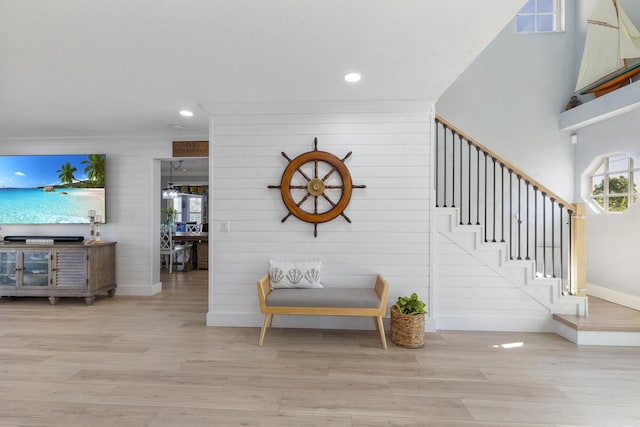 staircase with wood finished floors, baseboards, recessed lighting, and wooden walls