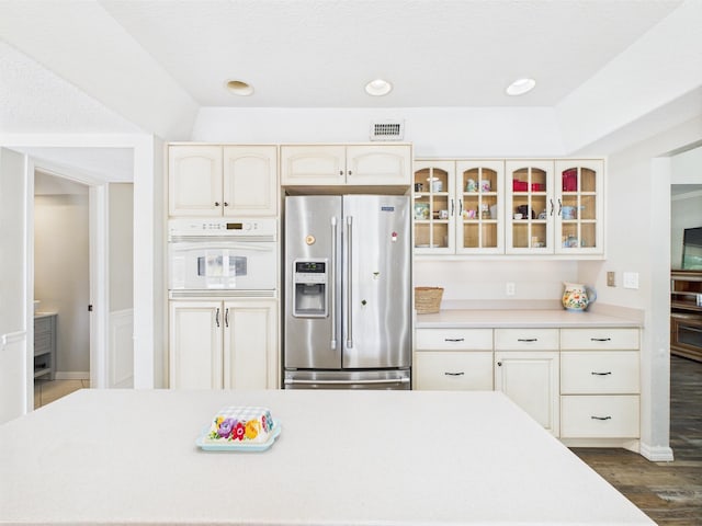 2045 SW 18th Ln, Okeechobee, FL 34974 - kitchen with stainless steel fridge with ice dispenser, white oven, glass insert cabinets, light countertops, and dark wood-style flooring
