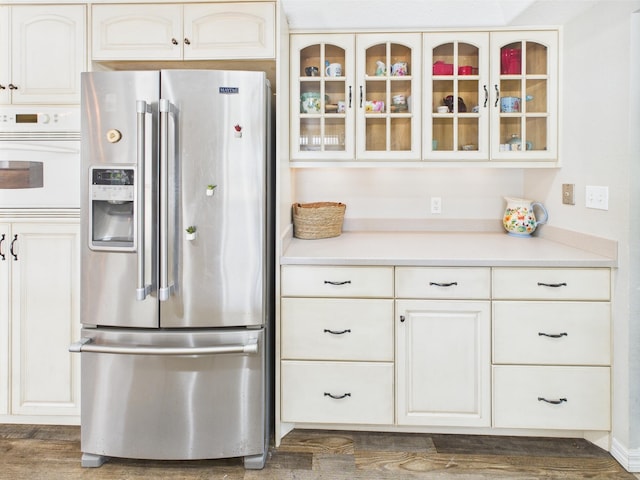 2045 SW 18th Ln, Okeechobee, FL 34974 - kitchen featuring stainless steel fridge with ice dispenser, white oven, glass insert cabinets, and light countertops