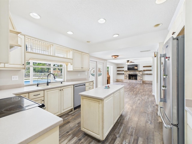 2045 SW 18th Ln, Okeechobee, FL 34974 - kitchen with stainless steel appliances, a sink, open floor plan, cream cabinets, and a textured ceiling
