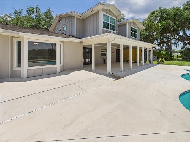 2045 SW 18th Ln, Okeechobee, FL 34974 - rear view of property with board and batten siding, a patio, and an outdoor pool