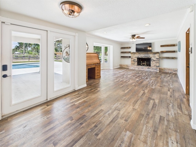 2045 SW 18th Ln, Okeechobee, FL 34974 - unfurnished living room with wood finished floors, ceiling fan, crown molding, a brick fireplace, and baseboards