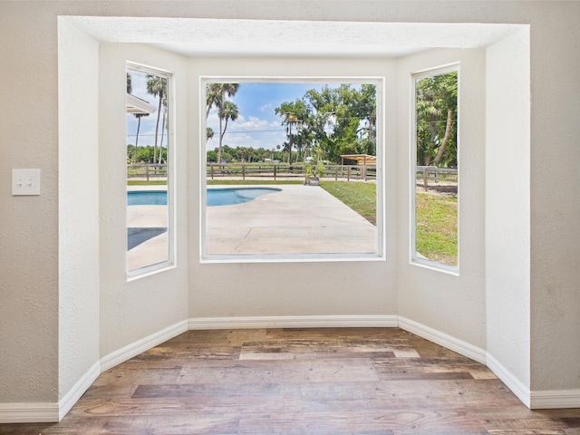 2045 SW 18th Ln, Okeechobee, FL 34974 - unfurnished room with a textured wall, plenty of natural light, baseboards, and wood finished floors