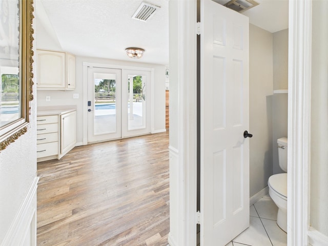 2045 SW 18th Ln, Okeechobee, FL 34974 - bathroom featuring wood finished floors, toilet, baseboards, and french doors