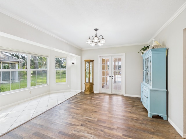 2045 SW 18th Ln, Okeechobee, FL 34974 - unfurnished dining area with wood finished floors, a chandelier, crown molding, french doors, and baseboards