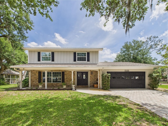 2045 SW 18th Ln, Okeechobee, FL 34974 - traditional home featuring a garage, a front yard, decorative driveway, board and batten siding, and brick siding