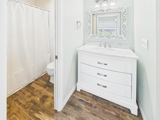 2045 SW 18th Ln, Okeechobee, FL 34974 - full bathroom with wood finished floors, toilet, vanity, baseboards, and a shower with shower curtain