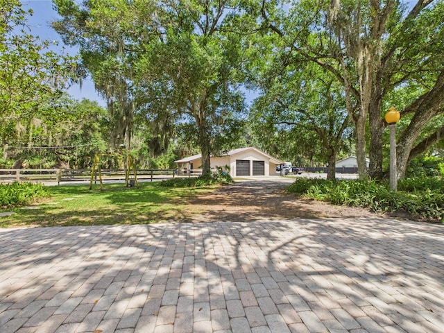 2045 SW 18th Ln, Okeechobee, FL 34974 - view of patio / terrace featuring view of scattered trees, driveway, and an attached garage