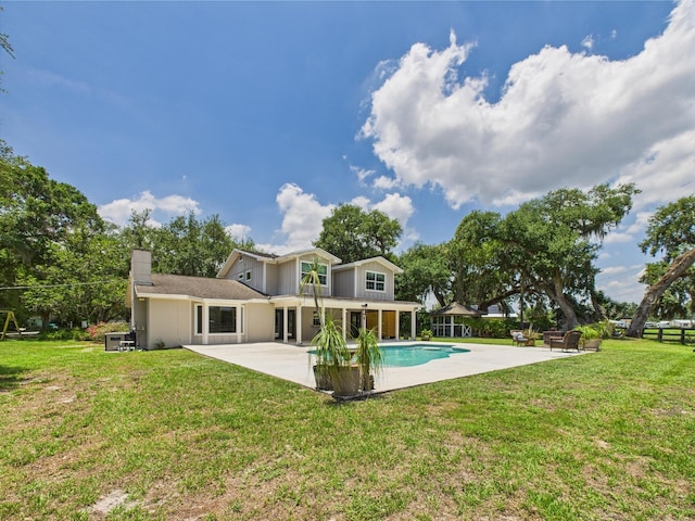 2045 SW 18th Ln, Okeechobee, FL 34974 - back of property featuring a patio, an outdoor pool, a lawn, and a chimney