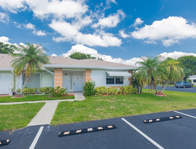 517 SE Crooked Lake Ln Unit D, Fort Pierce, FL 34982 - view of front of house featuring uncovered parking, a front yard, and stucco siding