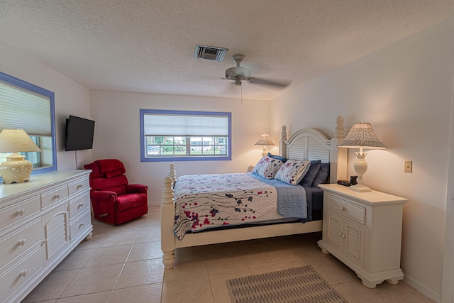 517 SE Crooked Lake Ln Unit D, Fort Pierce, FL 34982 - bedroom featuring light tile patterned flooring, ceiling fan, a textured ceiling, and baseboards
