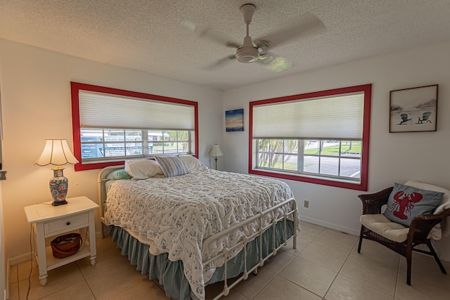 517 SE Crooked Lake Ln Unit D, Fort Pierce, FL 34982 - bedroom featuring light tile patterned floors, a textured ceiling, ceiling fan, and baseboards