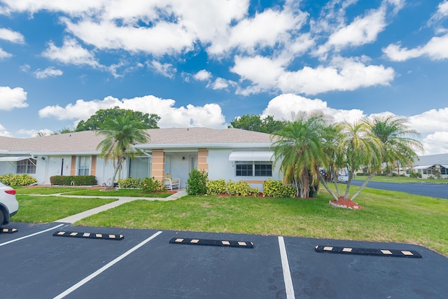 517 SE Crooked Lake Ln Unit D, Fort Pierce, FL 34982 - view of front facade with uncovered parking, stucco siding, and a front yard
