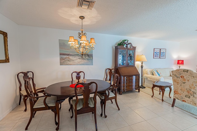 517 SE Crooked Lake Ln Unit D, Fort Pierce, FL 34982 - dining room featuring a chandelier, a textured ceiling, light tile patterned floors, and baseboards