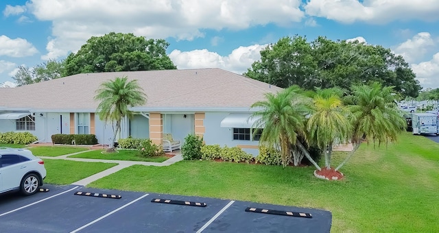 517 SE Crooked Lake Ln Unit D, Fort Pierce, FL 34982 - view of front of home with uncovered parking, a front lawn, and stucco siding