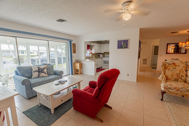 517 SE Crooked Lake Ln Unit D, Fort Pierce, FL 34982 - living area featuring light tile patterned flooring, a textured ceiling, ceiling fan, and a chandelier