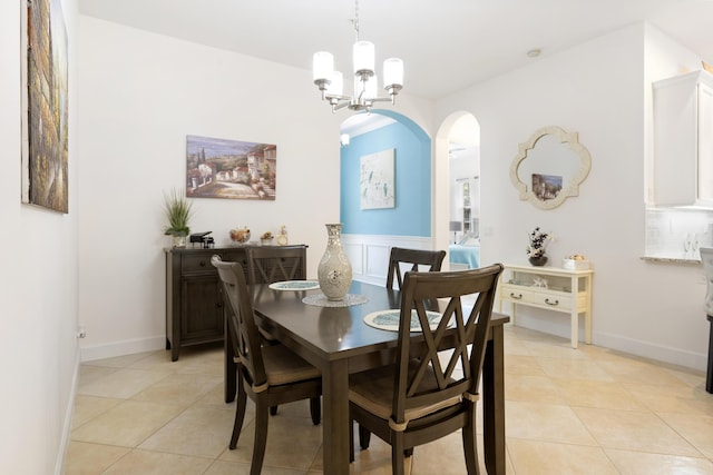 10171 SW Dolce Rd, Port Saint Lucie, FL 34986 - dining area featuring light tile patterned flooring, a chandelier, arched walkways, and baseboards