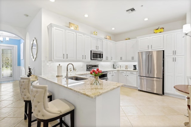 10171 SW Dolce Rd, Port Saint Lucie, FL 34986 - kitchen with appliances with stainless steel finishes, a sink, light tile patterned floors, a peninsula, and recessed lighting
