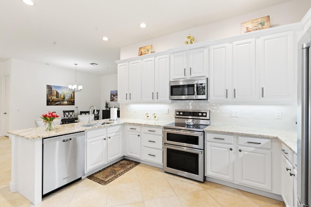 10171 SW Dolce Rd, Port Saint Lucie, FL 34986 - kitchen with appliances with stainless steel finishes, a peninsula, a sink, decorative backsplash, and a chandelier