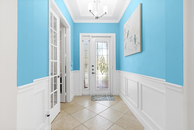 10171 SW Dolce Rd, Port Saint Lucie, FL 34986 - foyer featuring wainscoting, a chandelier, a decorative wall, light tile patterned flooring, and ornamental molding