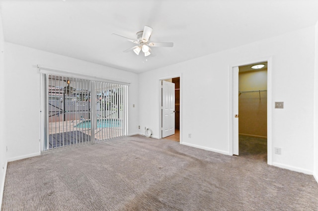 8586 Brian Blvd, Boynton Beach, FL 33472 - unfurnished bedroom featuring a walk in closet, carpet, baseboards, and access to outside