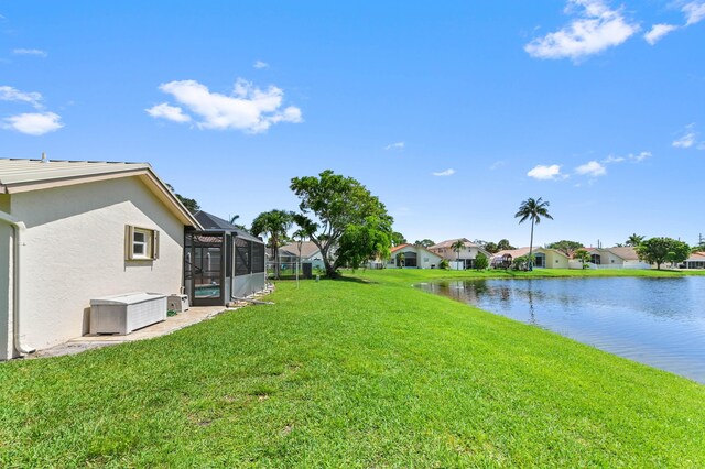 8586 Brian Blvd, Boynton Beach, FL 33472 - view of grassy yard with a residential view, glass enclosure, a water view, and a patio