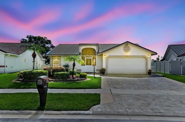 8586 Brian Blvd, Boynton Beach, FL 33472 - view of front of house featuring decorative driveway, stucco siding, a garage, and metal roof