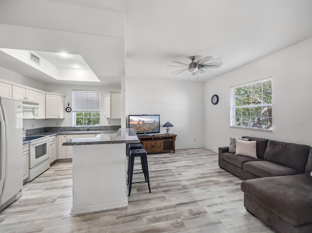 10520 SW Stephanie Way Unit 2-202, Port Saint Lucie, FL 34987 - kitchen with white appliances, a breakfast bar, plenty of natural light, and open floor plan