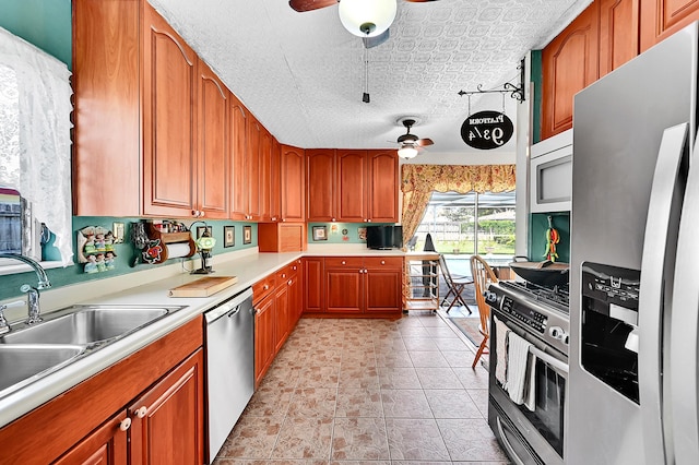 1328 SE 3rd Ave, Deerfield Beach, FL 33441 - kitchen with stainless steel appliances, ceiling fan, brown cabinetry, light countertops, and a sink