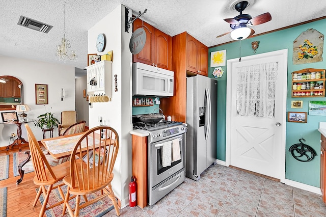 1328 SE 3rd Ave, Deerfield Beach, FL 33441 - kitchen featuring stainless steel appliances, ceiling fan, a textured ceiling, brown cabinetry, and light tile patterned floors
