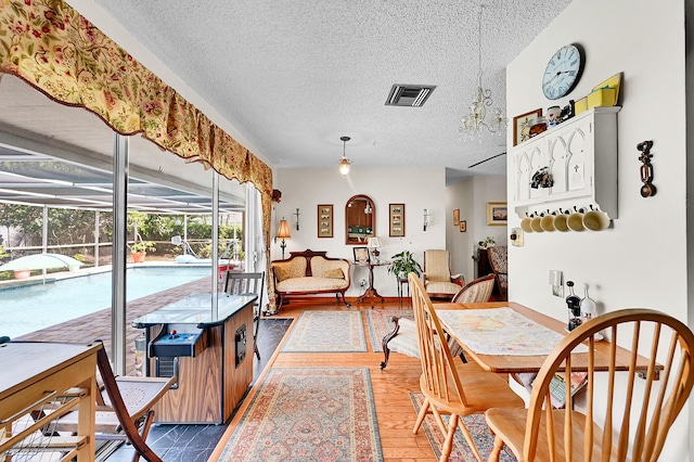 1328 SE 3rd Ave, Deerfield Beach, FL 33441 - dining space featuring a textured ceiling, a sunroom, and wood finished floors