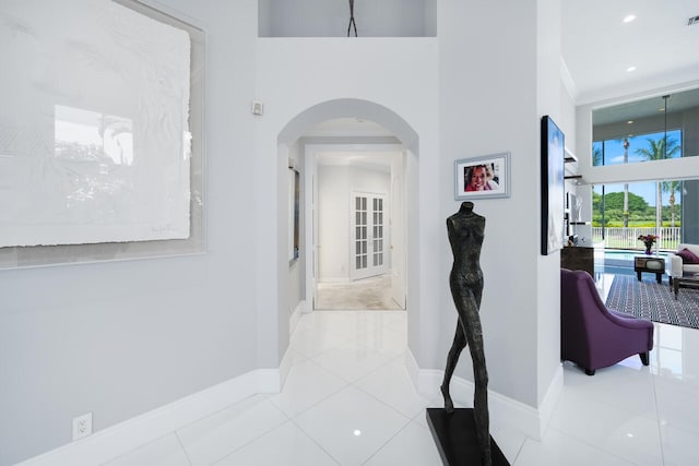 6051 NW 24th Ter, Boca Raton, FL 33496 - corridor with arched walkways, tile patterned flooring, baseboards, and a high ceiling