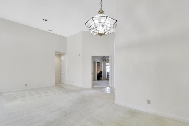 135 Eagleton Ct, Palm Beach Gardens, FL 33418 - unfurnished room featuring light colored carpet, a chandelier, a high ceiling, and baseboards