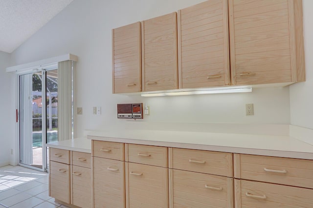 135 Eagleton Ct, Palm Beach Gardens, FL 33418 - kitchen featuring light brown cabinets, lofted ceiling, light countertops, and light tile patterned floors