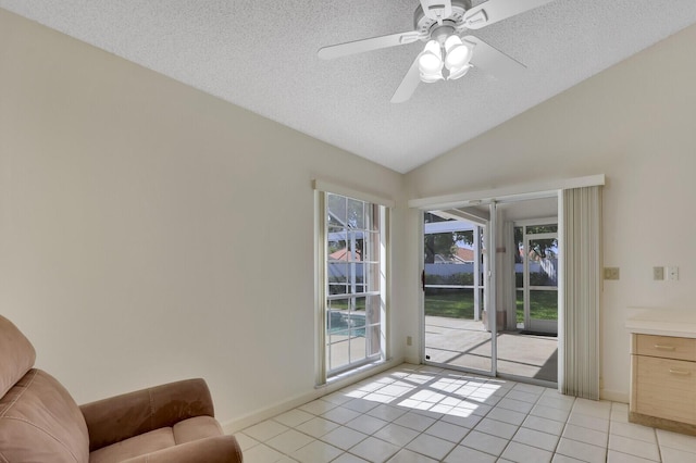 135 Eagleton Ct, Palm Beach Gardens, FL 33418 - living room featuring a textured ceiling, vaulted ceiling, light tile patterned floors, ceiling fan, and baseboards