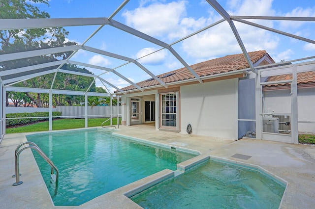 135 Eagleton Ct, Palm Beach Gardens, FL 33418 - view of swimming pool featuring a patio area, a pool with connected hot tub, glass enclosure, and central AC unit