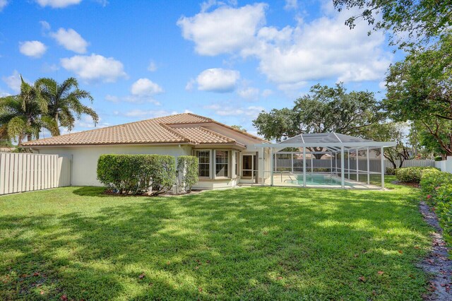 135 Eagleton Ct, Palm Beach Gardens, FL 33418 - rear view of property featuring a tiled roof, stucco siding, and glass enclosure