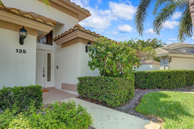 135 Eagleton Ct, Palm Beach Gardens, FL 33418 - view of exterior entry with stucco siding and a tile roof