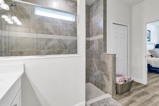 6020 Wild Olive Way, Vero Beach, FL 32966 - bathroom with connected bathroom, wood finished floors, walk in shower, vanity, and baseboards