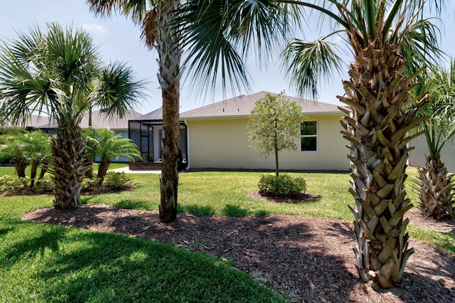 6020 Wild Olive Way, Vero Beach, FL 32966 - view of property exterior featuring stucco siding, a lawn, and glass enclosure