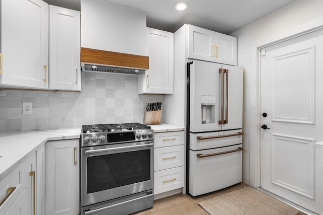 220 Fordham Dr, Lake Worth Beach, FL 33460 - kitchen with white refrigerator with ice dispenser, gas stove, white cabinetry, light stone counters, and tasteful backsplash