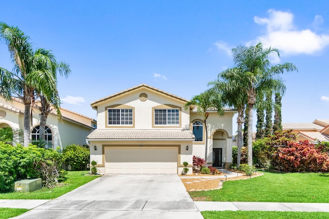 mediterranean / spanish home featuring stucco siding, an attached garage, driveway, a front yard, and a tile roof